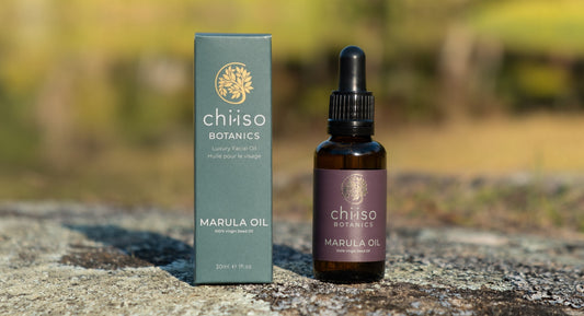 “Chiiso Botanics cold-pressed Marula Oil bottle and packaging outdoors on natural rock surface.